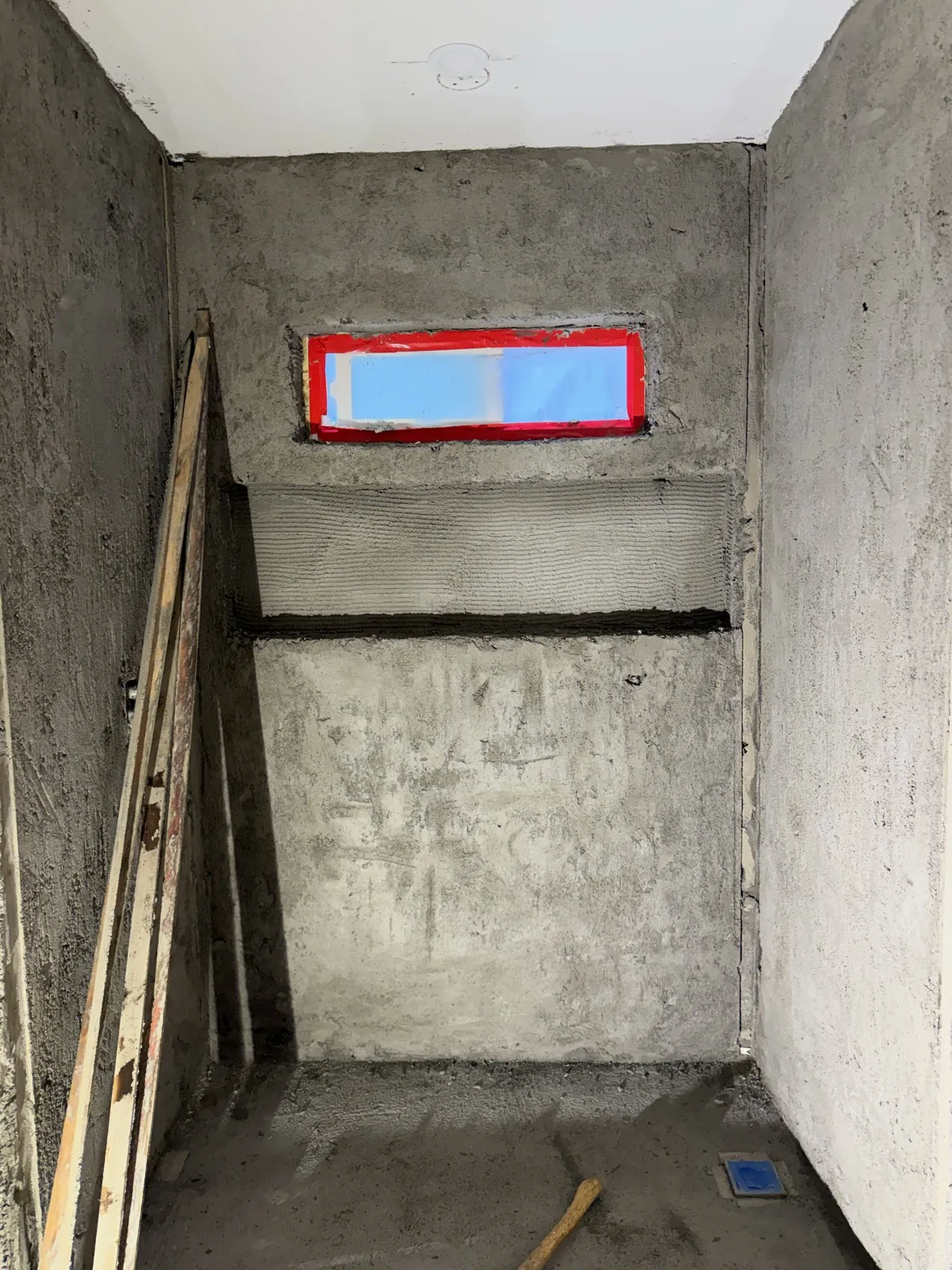 Bathroom shower area during construction with scratch coat walls and mortar bed