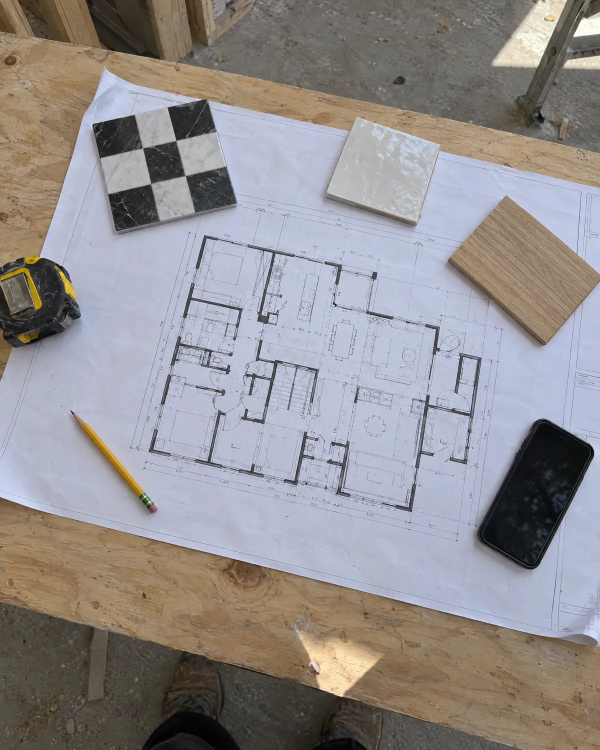 Floor plan set with tile, white oak and material samples laid out for planning