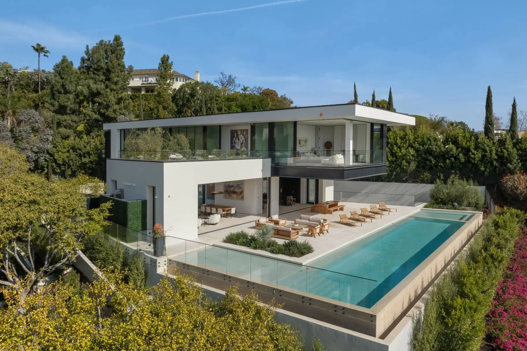 Infinity-edge pool and pool terrace beside the two-story home at the Laurel Way custom home in Beverly Hills, built by Valley Vista Builders