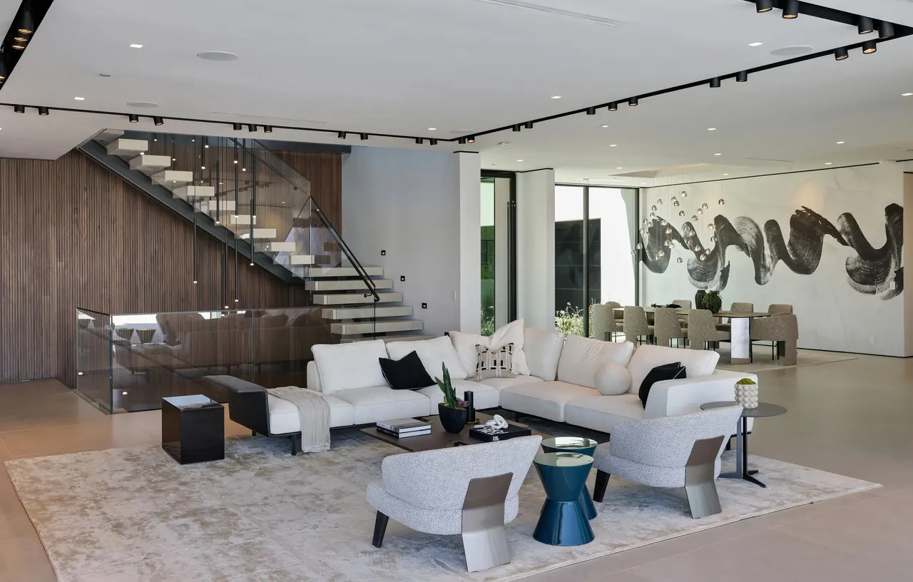 Open living room with a floating stair and a walnut slat wall at the Laurel View Residence, a Hollywood Hills home built by Valley Vista Builders