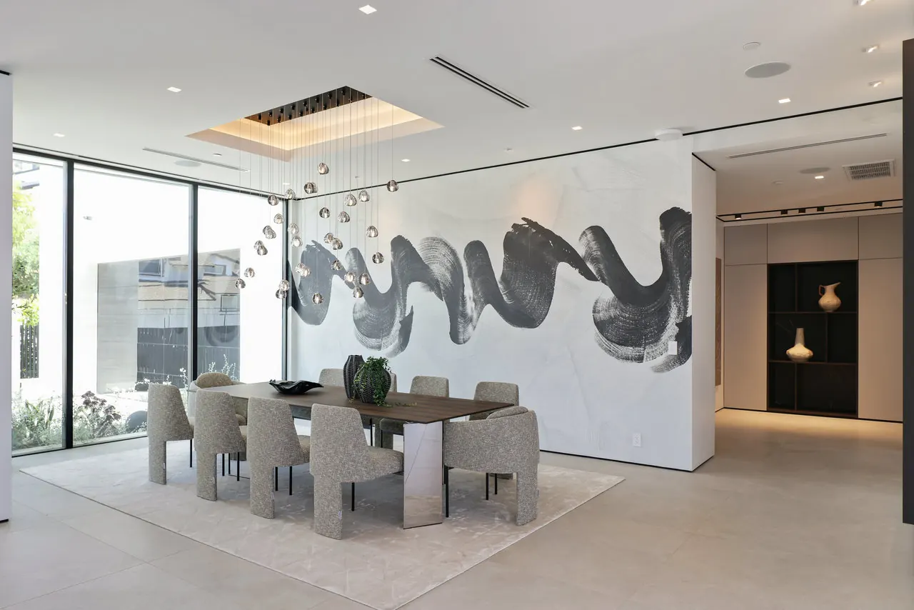 Dining room with a cluster of glass pendants and a large brushstroke wall mural at the Laurel View Residence, a Hollywood Hills home built by Valley Vista Builders
