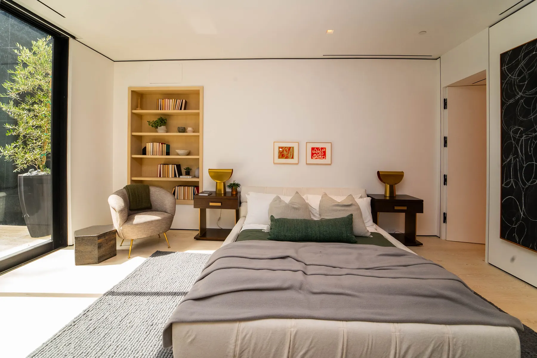 Bedroom with a built-in oak bookcase and a floor-to-ceiling window at the Laurel Way custom home in Beverly Hills, built by Valley Vista Builders
